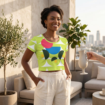 Good Wishes 365 green mushroom print crop tee worn by a smiling woman on a sunny rooftop terrace.