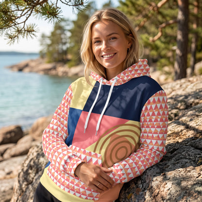 Good Wishes 365 recycled hoodie with 80s Memphis geometric print in navy, yellow, and coral worn by a smiling woman.