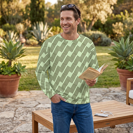 Good Wishes 365 unisex sweatshirt with mint and dark geometric print worn by a smiling man reading in a garden.