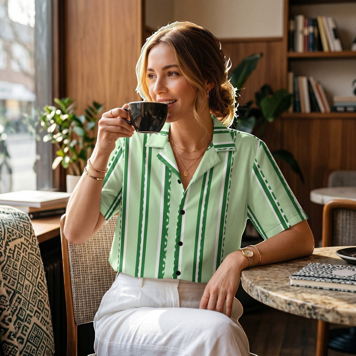 Good Wishes 365 pastel mint vertical stripe button-down shirt with UPF50+ protection worn by a woman in a cafe.