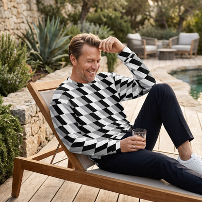 Good Wishes 365 unisex sweatshirt with a black, white, and gray optical illusion print worn by a man on a lounge chair