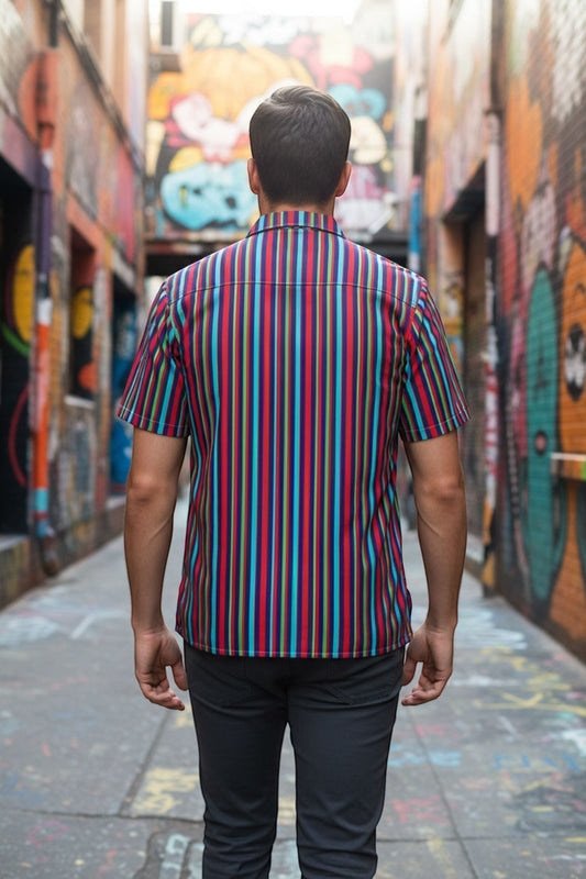 Good Wishes 365 multicolor striped button-down shirt with an oversized fit worn by a man in an urban alleyway.