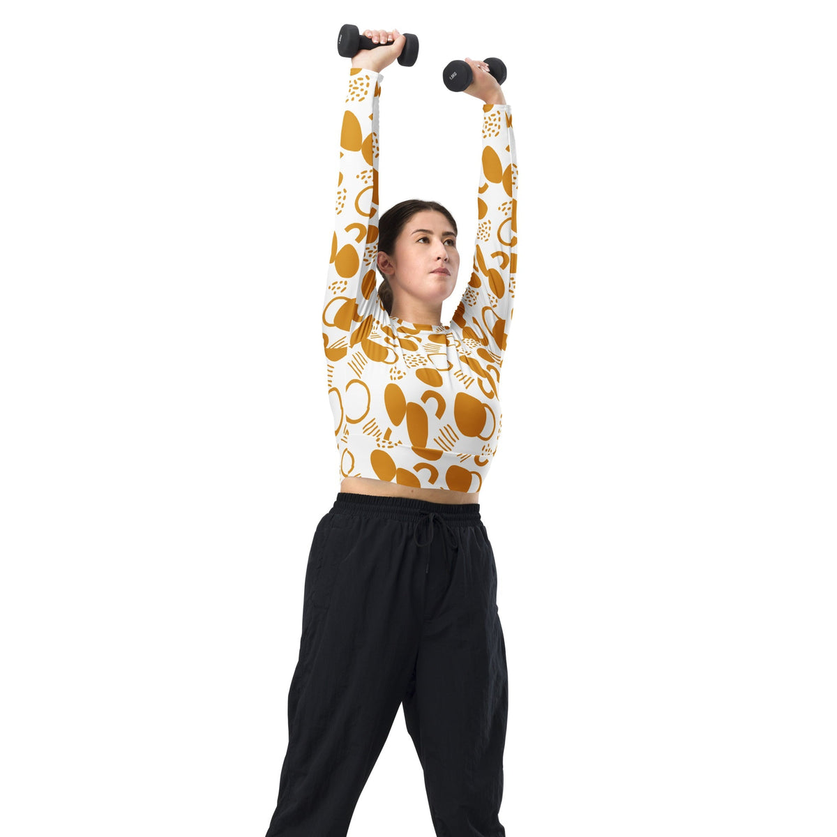 Good Wishes 365 mustard yellow abstract geometric print long-sleeve crop top worn by a woman lifting dumbbells