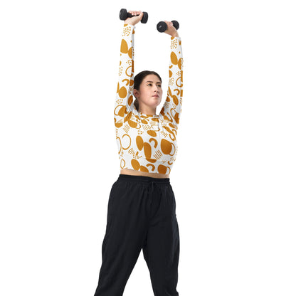 Good Wishes 365 mustard yellow abstract geometric print long-sleeve crop top worn by a woman lifting dumbbells