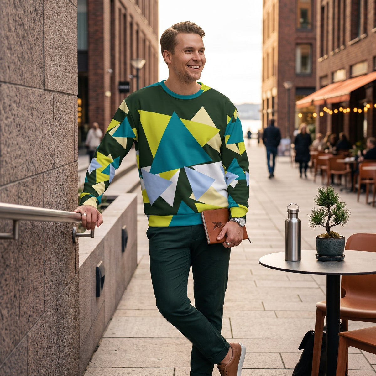 Good Wishes 365 men's myrtle green sweatshirt with abstract triangle print, worn by a man on a city street.