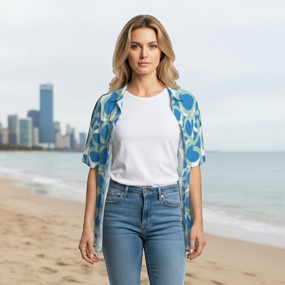 Good Wishes 365 navy blue retro geometric print short sleeve button shirt worn over a white tee on a beach.