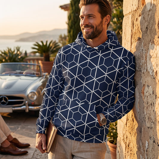 Good Wishes 365 navy hoodie with white geometric hexagon print worn by a smiling man leaning against a stone wall