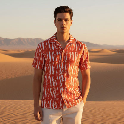 Good Wishes 365 unisex short-sleeve button shirt in orange with white abstract print, worn in a desert setting.