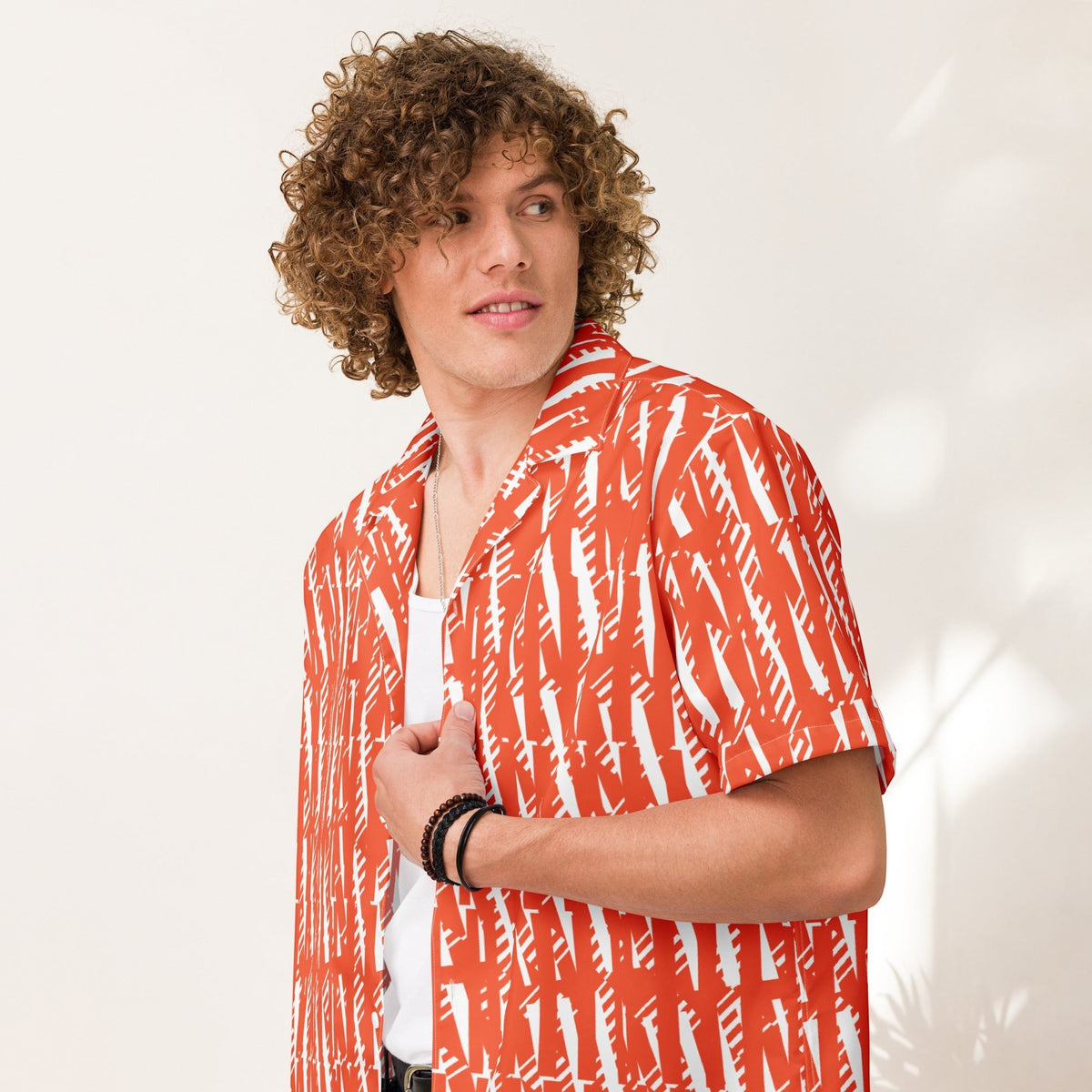 Good Wishes 365 unisex button-up shirt in orange with white abstract print, made from lightweight moisture-wicking fabric.