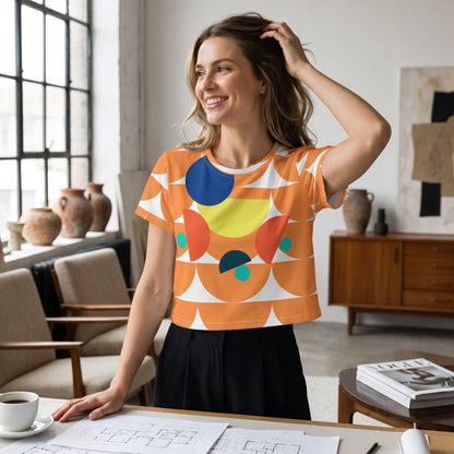 Good Wishes 365 orange crop tee with mushroom and geometric print worn by a smiling woman in a bright studio.