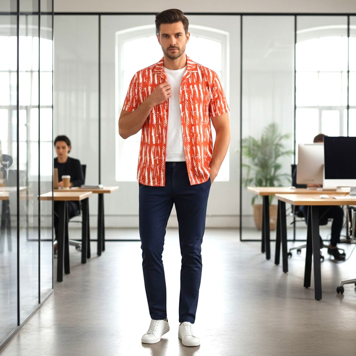 Good Wishes 365 unisex button shirt in orange with white pattern, worn over a white tee in a modern office setting.