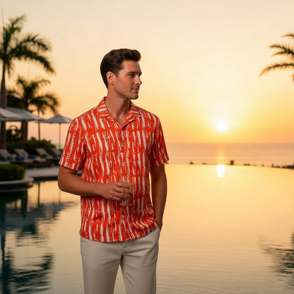 Good Wishes 365 unisex orange patterned button shirt with UPF50+ protection worn by a man at a sunset pool resort.