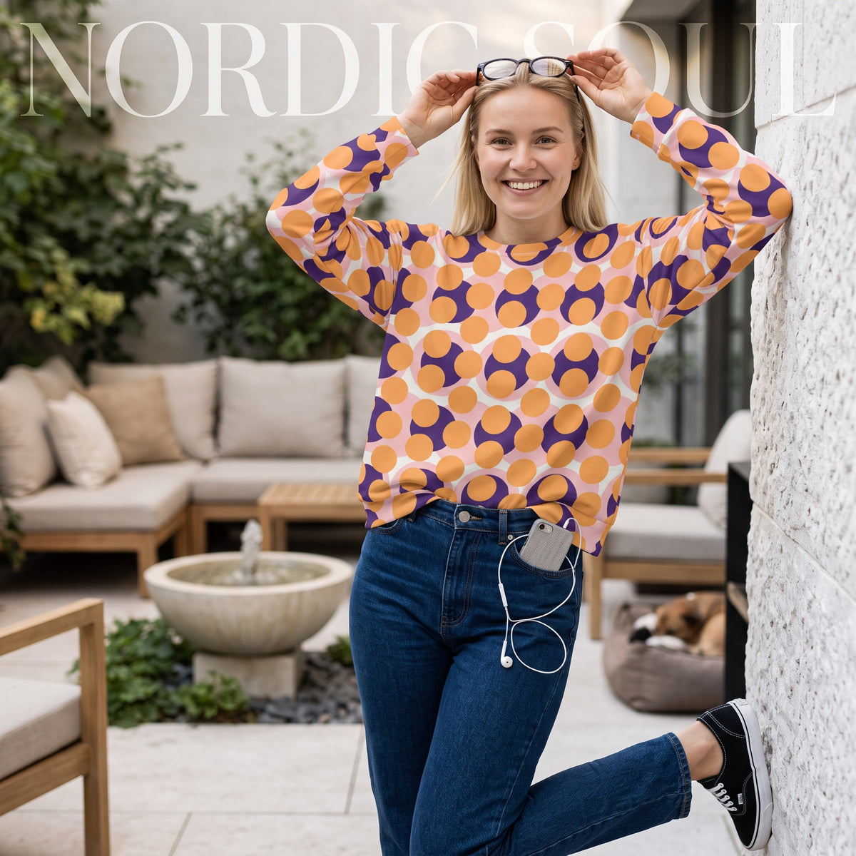 Good Wishes 365 women's recycled orange sweatshirt with 70s pop art circle print, worn by a smiling blonde woman.