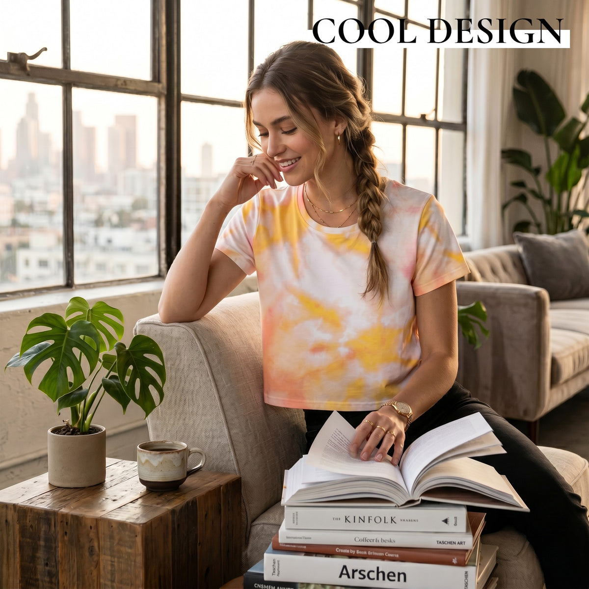 Good Wishes 365 orange and harvest gold tie-dye crop tee worn by a woman reading a book in a sunlit living room.