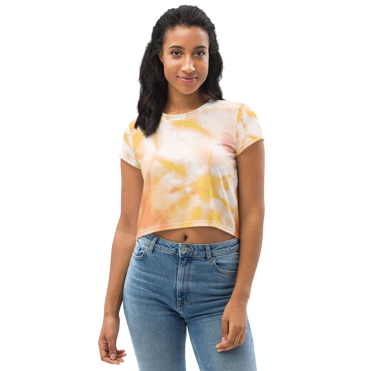 Good Wishes 365 model wearing a short sleeve crew neck crop top with an orange and yellow tie-dye pattern and blue jeans