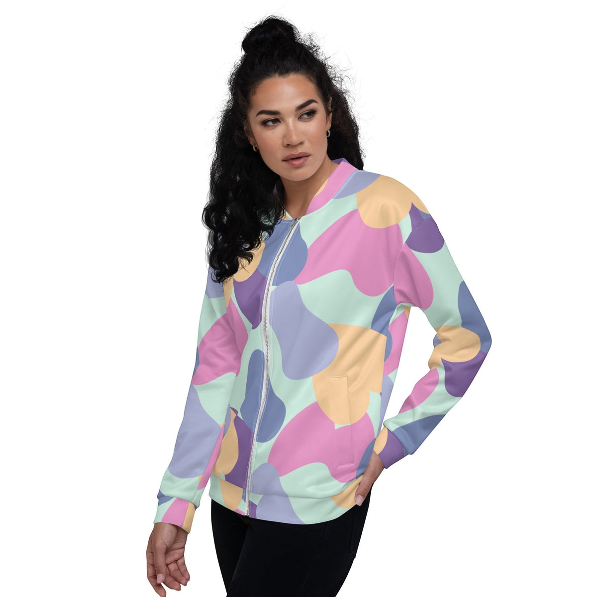A woman wearing a Good Wishes 365 pastel bomber jacket with a vibrant abstract print in mint, lavender, and peach.