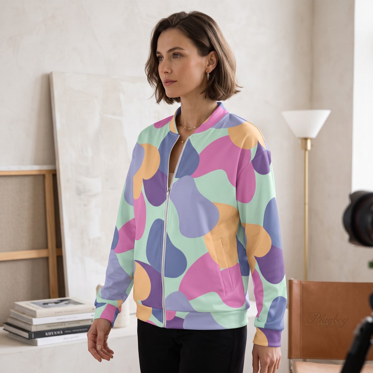 Good Wishes 365 unisex bomber jacket with pastel abstract print, silver zipper, and brushed fleece lining on a model.