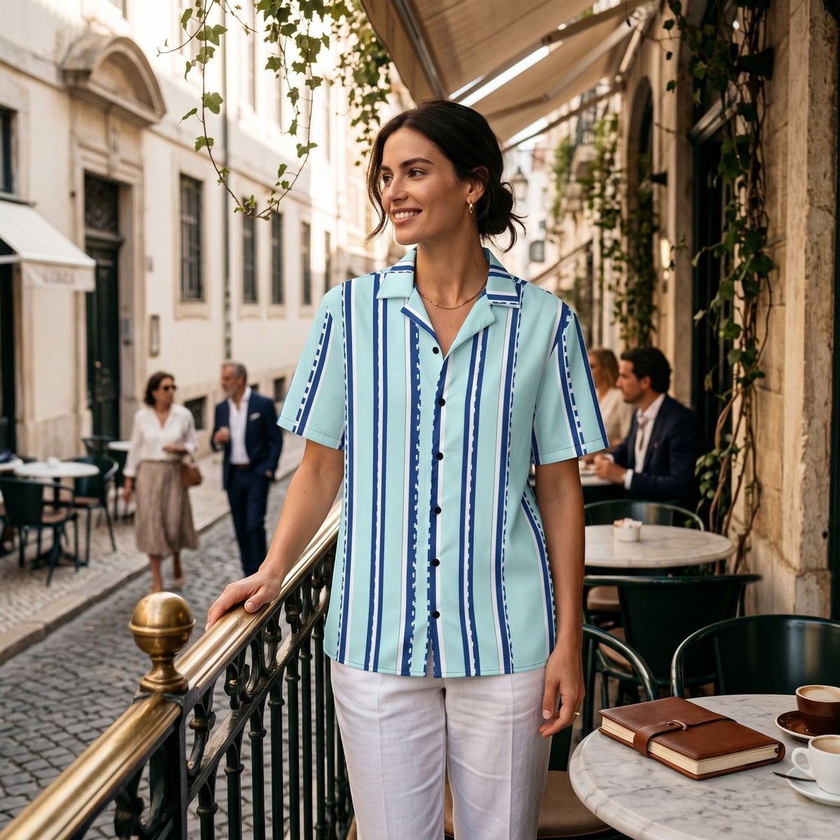 Good Wishes 365 retro pastel cyan button-down shirt with navy vertical stripes worn by a woman at an outdoor cafe.