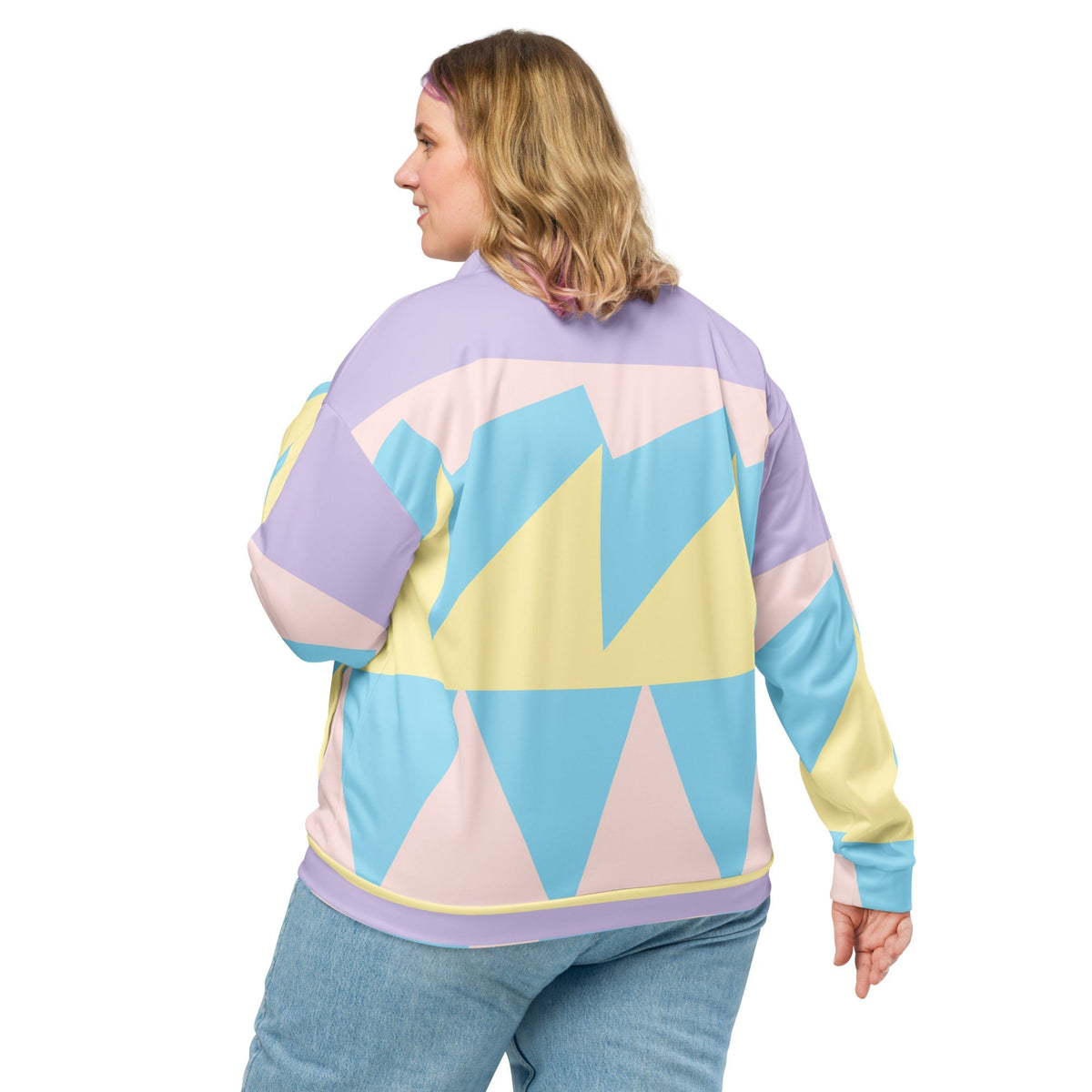 Good Wishes 365 unisex bomber jacket with a pastel geometric print in yellow, blue, and pink, worn by a woman.