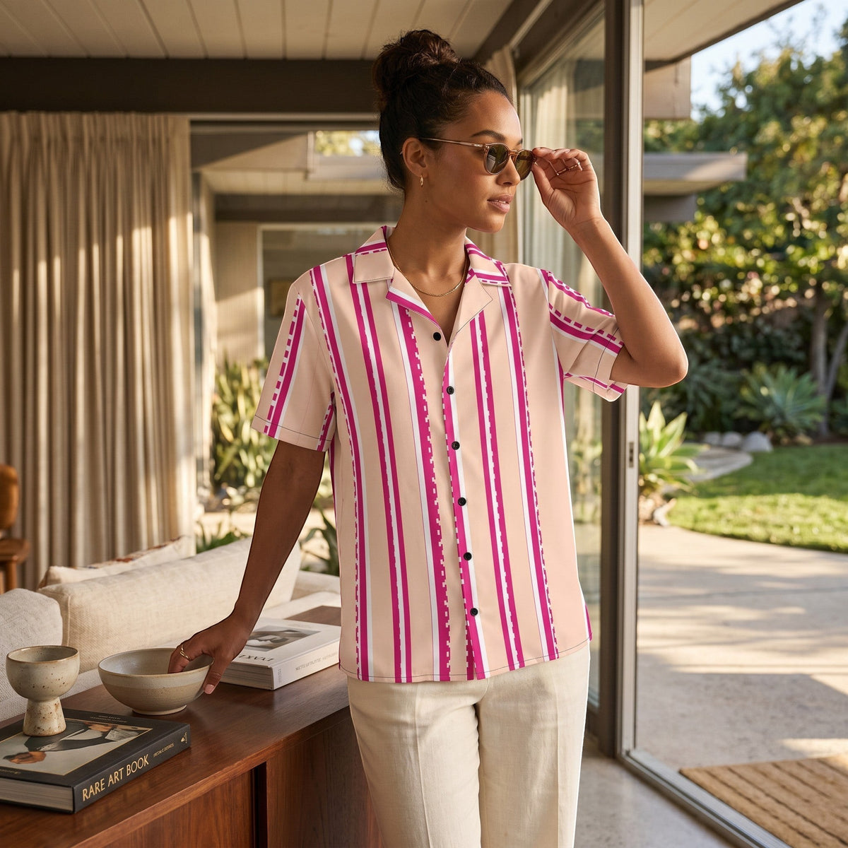 Good Wishes 365 retro pastel blush button-down shirt with magenta stripes, worn by a woman in a sunny living room.