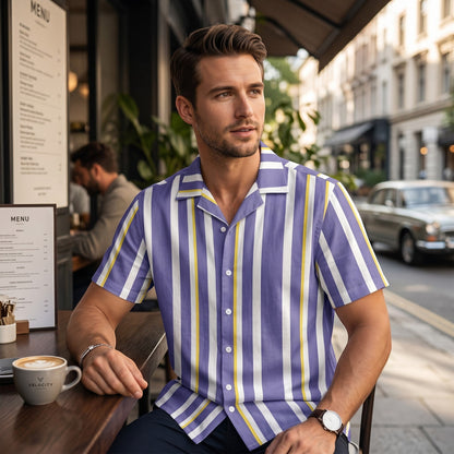 Good Wishes 365 men's periwinkle, white, and yellow vertical striped short sleeve camp collar shirt worn at a cafe.