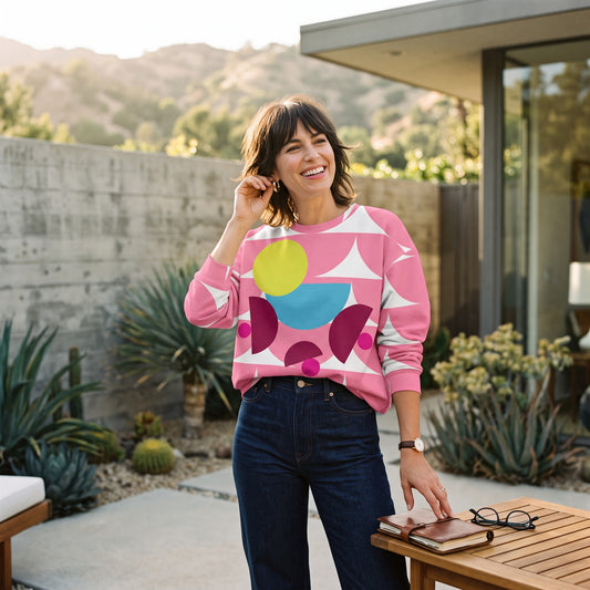 Good Wishes 365 pink recycled sweatshirt featuring a geometric mushroom graphic, worn by a smiling woman outdoors.