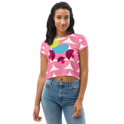 Model wearing a Good Wishes 365 pink crop tee with a geometric mushroom graphic in yellow, blue, and magenta.