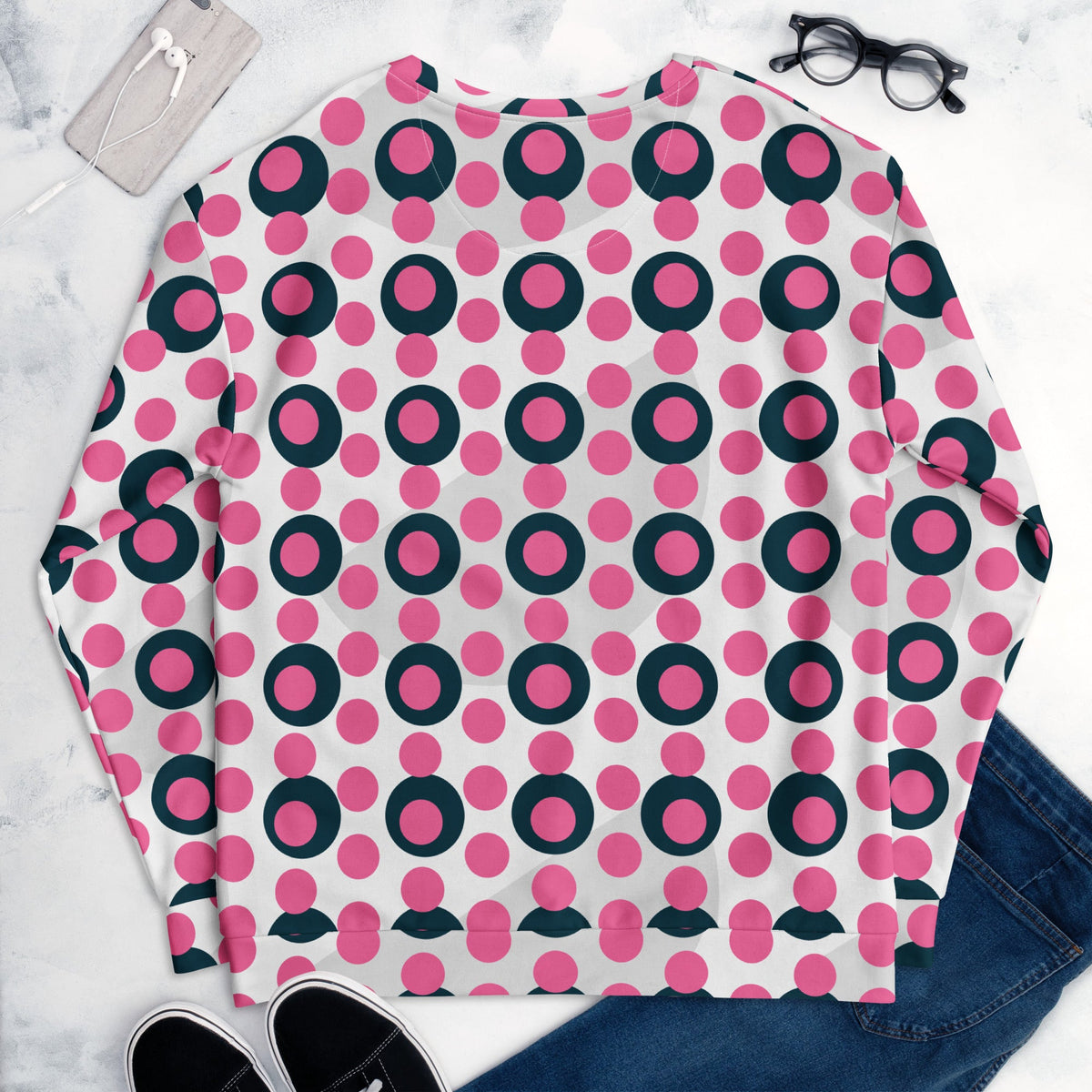 Good Wishes 365 unisex sweatshirt with a rose pink and charcoal polka dot print, flat lay with jeans and accessories.