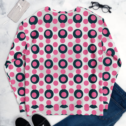 Good Wishes 365 unisex sweatshirt with a rose pink and charcoal polka dot print, flat lay with jeans and accessories.