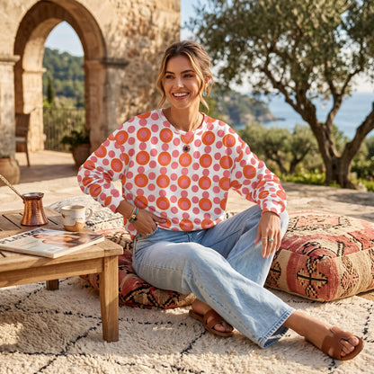 Good Wishes 365 recycled sweatshirt with pink and orange 70s pop art polka dot print worn by a smiling woman outdoors