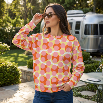 Good Wishes 365 recycled sweatshirt with 70s pop art pink, orange, and yellow print worn by a woman outdoors