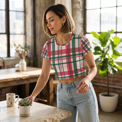 Good Wishes 365 woman wearing a pink and green plaid all-over print crop tee with jeans in a bright loft setting.