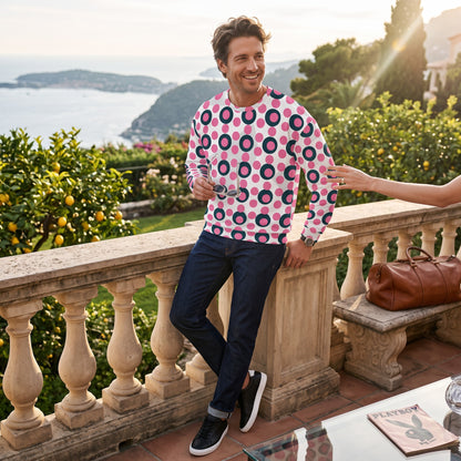 Good Wishes 365 unisex sweatshirt with rose pink and charcoal polka dot print, worn by a man on a sunny terrace.