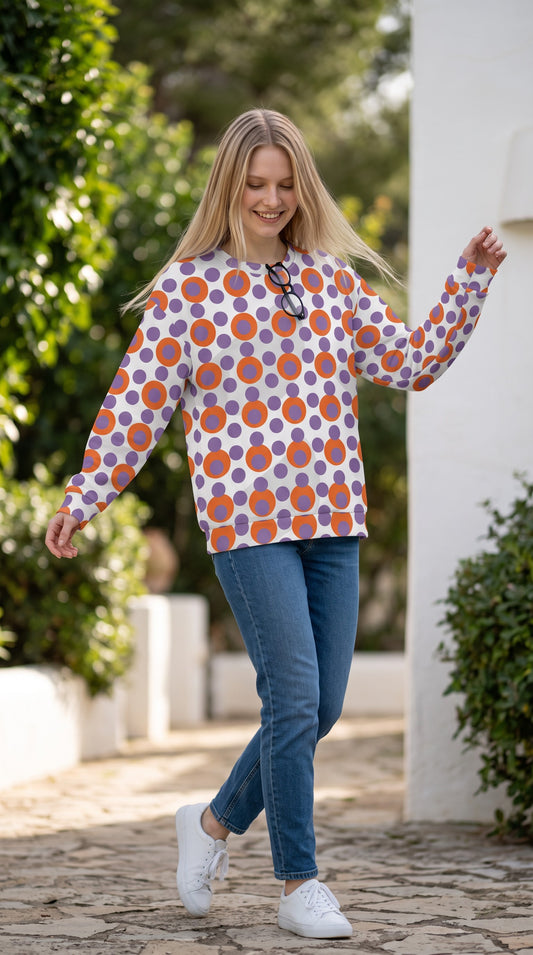 Good Wishes 365 recycled sweatshirt with 70s pop art orange and purple polka dot print on a woman in blue jeans