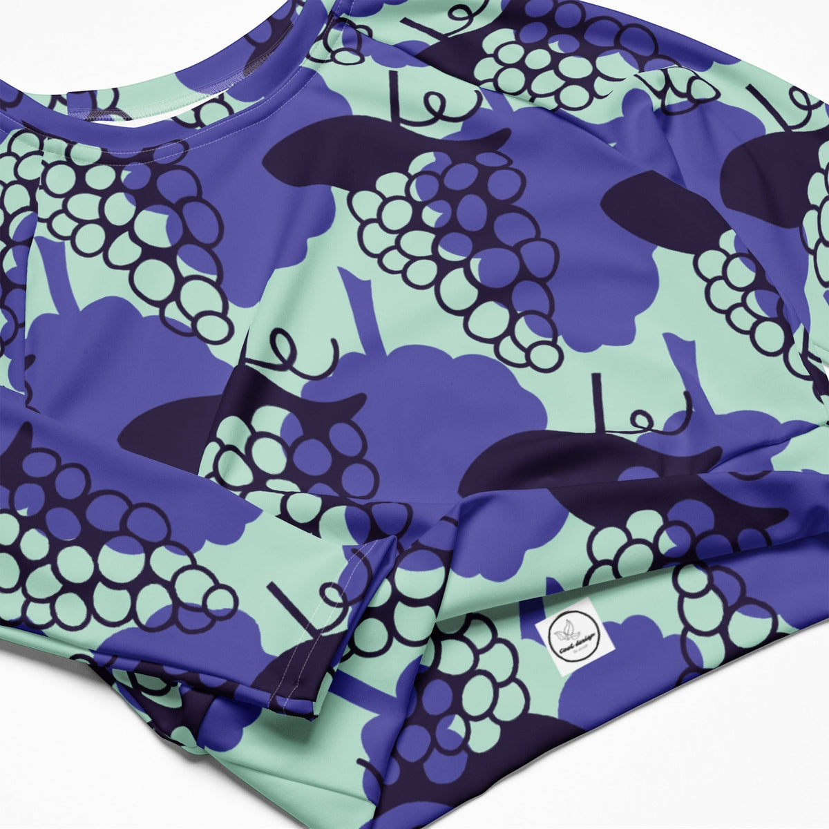 Good Wishes 365 long-sleeve crop top in recycled fabric with a purple and mint grape print pattern.