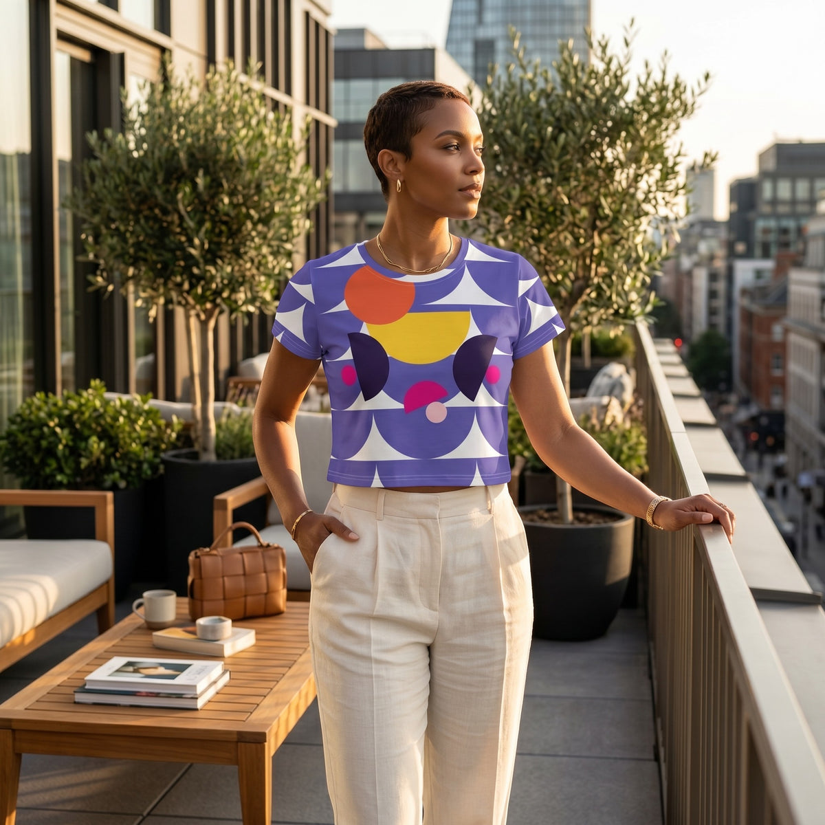Good Wishes 365 purple geometric mushroom graphic crop tee worn by a woman on a city balcony at sunset