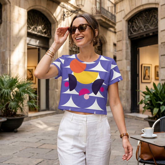 Good Wishes 365 purple crop tee with mushroom-inspired geometric print worn by a smiling woman in a city square.