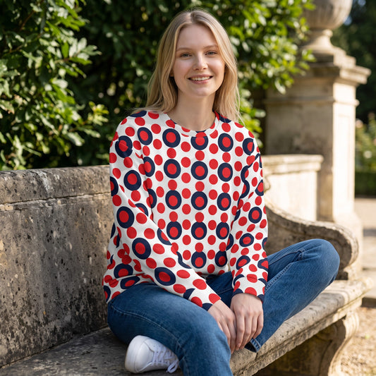 Good Wishes 365 recycled sweatshirt with 70s pop art red and navy polka dot print worn by a woman on a stone bench