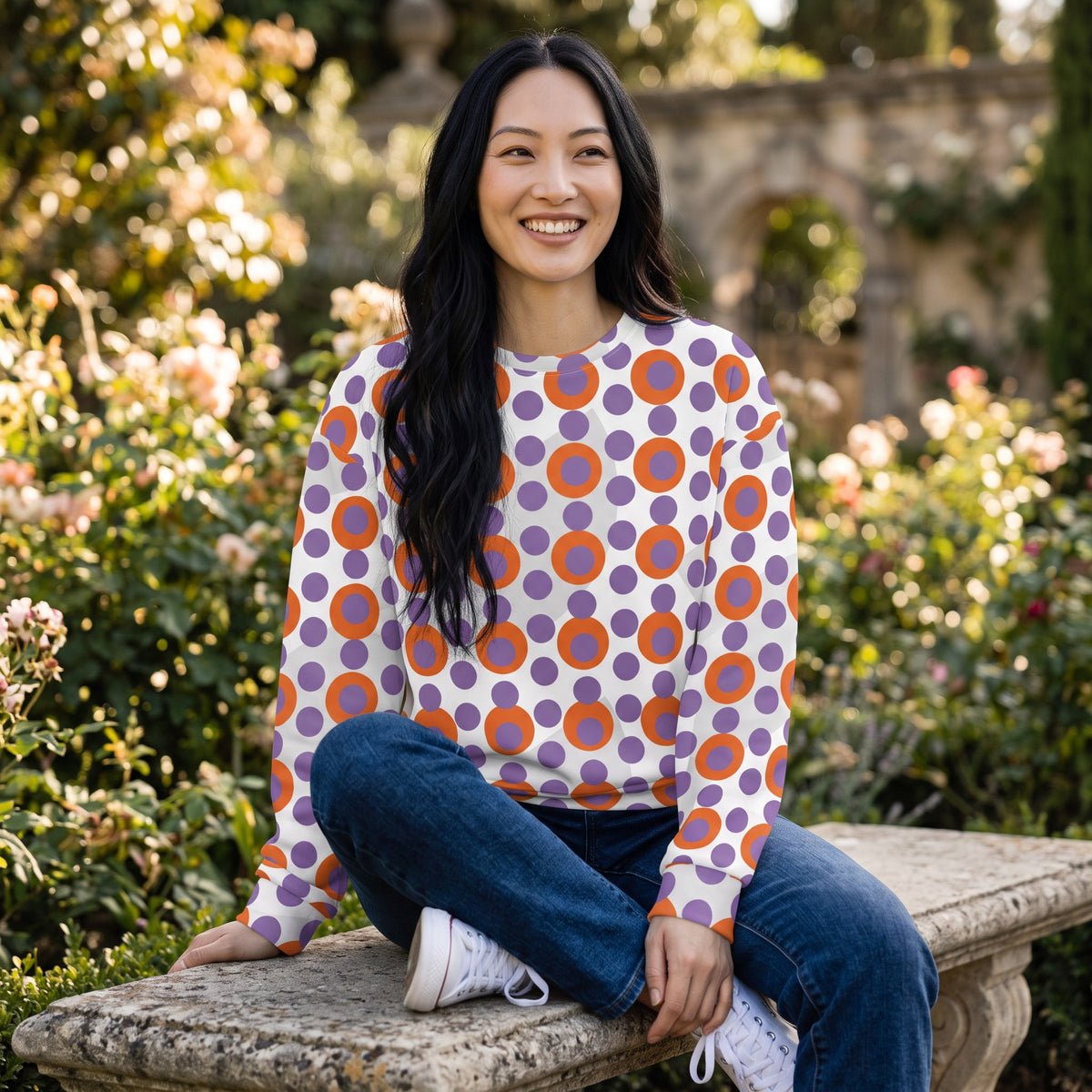 Good Wishes 365 women's recycled sweatshirt with 70s pop art orange and light purple polka dots on a white background.