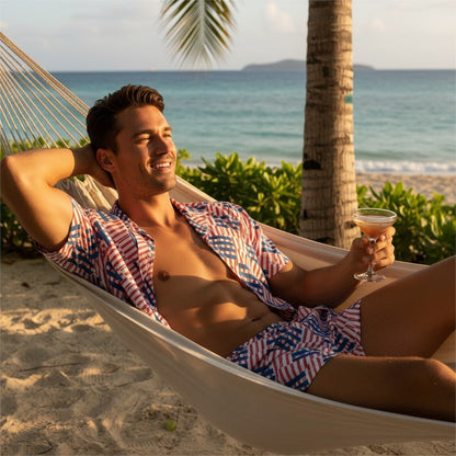 Good Wishes 365 man in a red and blue geometric print short-sleeve button-down shirt relaxing in a beach hammock.