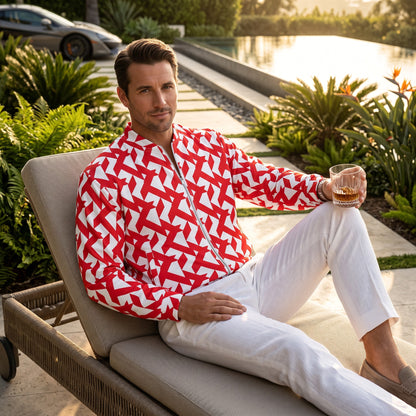 A man wearing a Good Wishes 365 red and white geometric maze print bomber jacket while relaxing by a pool.