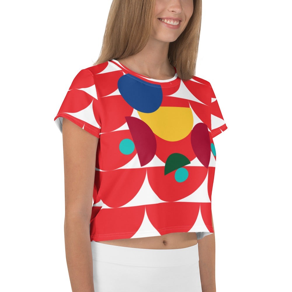Good Wishes 365 red crop tee with abstract geometric mushroom pattern in yellow, blue, and teal on a smiling model.