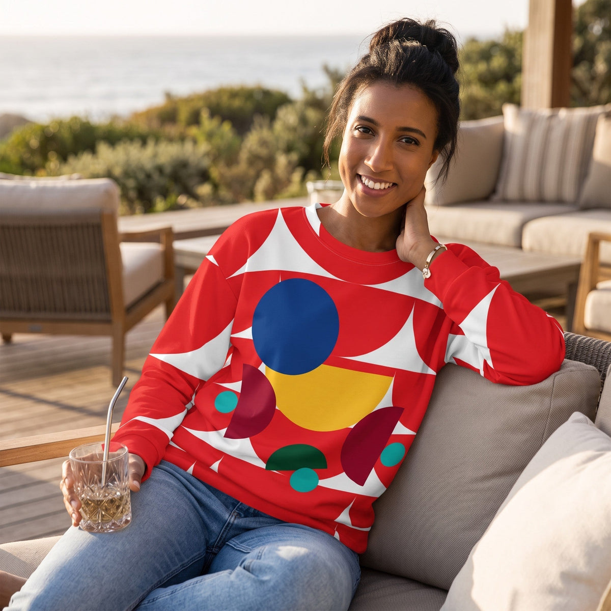 Good Wishes 365 red recycled sweatshirt with geometric mushroom print worn by a smiling woman on a patio.