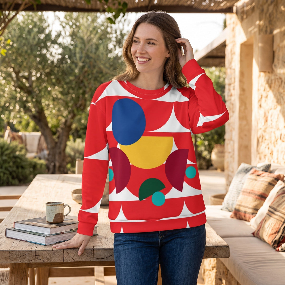 Good Wishes 365 red recycled sweatshirt with geometric mushroom print worn by a woman outdoors at a wooden table.