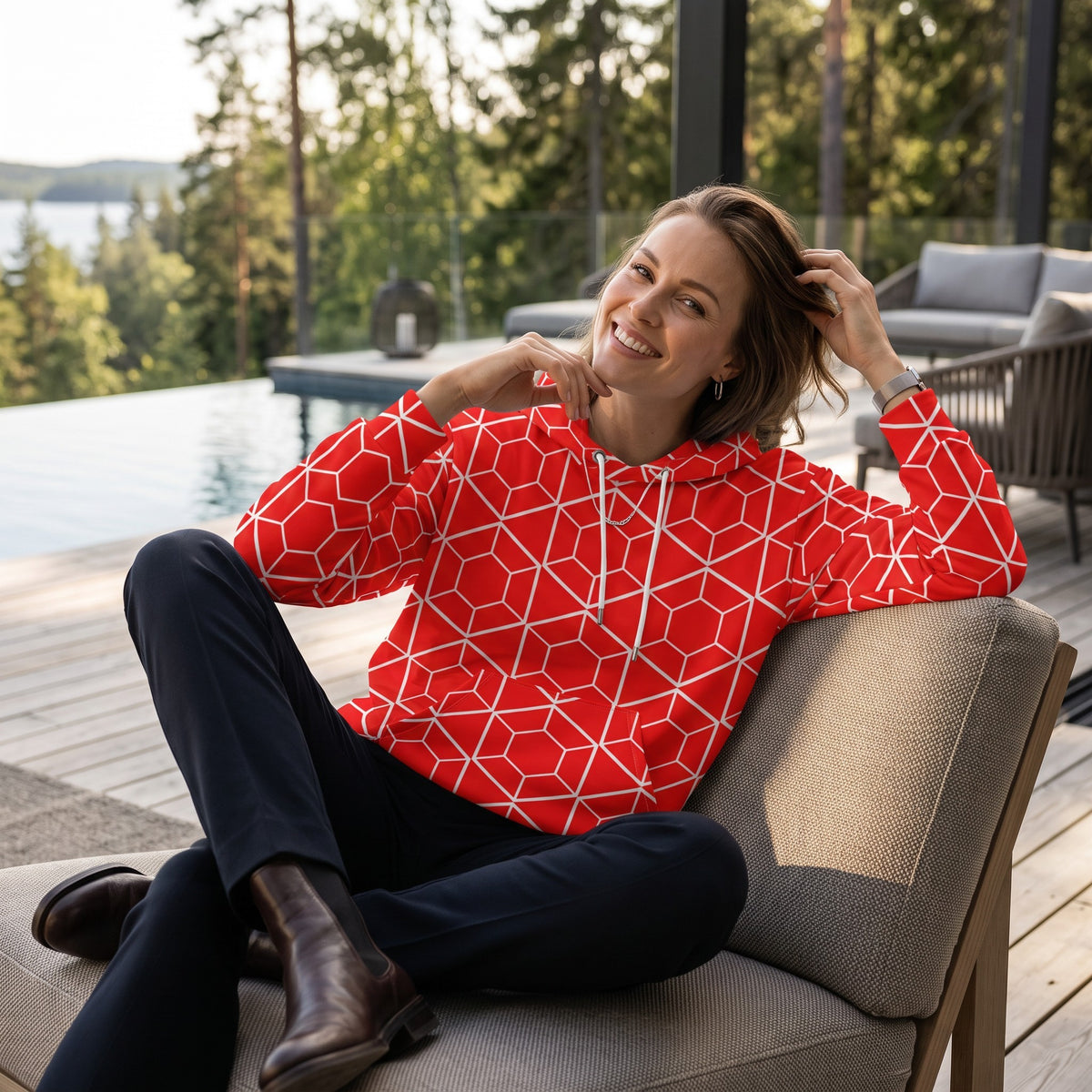 Good Wishes 365 red recycled hoodie with white geometric hexagon print worn by a woman on a modern outdoor patio