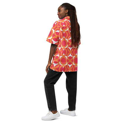 Good Wishes 365 unisex short sleeve button shirt with red and orange retro geometric pattern, worn with black jeans.