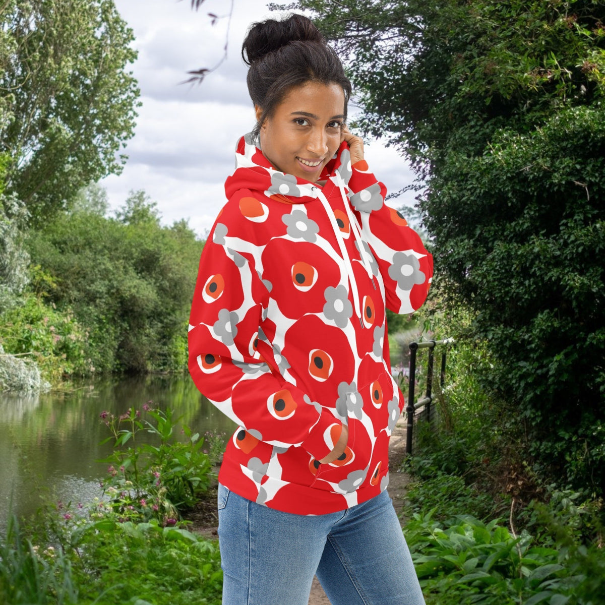 Good Wishes 365 recycled hoodie featuring a red and gray floral print, worn by a woman on a canal path.