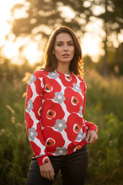 Good Wishes 365 unisex sweatshirt with red and gray floral print worn by a woman in a sunlit field
