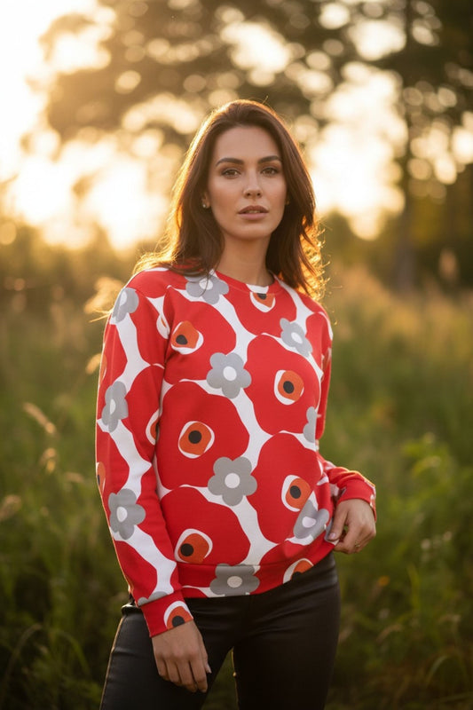 Good Wishes 365 unisex sweatshirt with red and gray floral print worn by a woman in a sunlit field