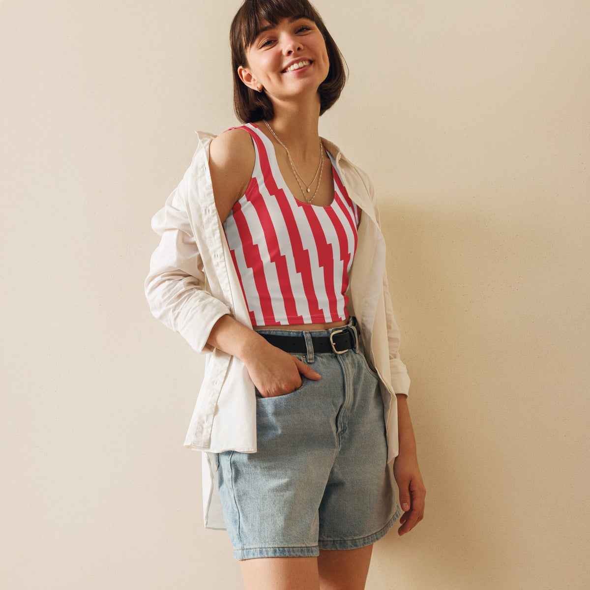 Good Wishes 365 red and white glitch stripe crop top worn by a smiling woman with a white shirt and denim shorts.